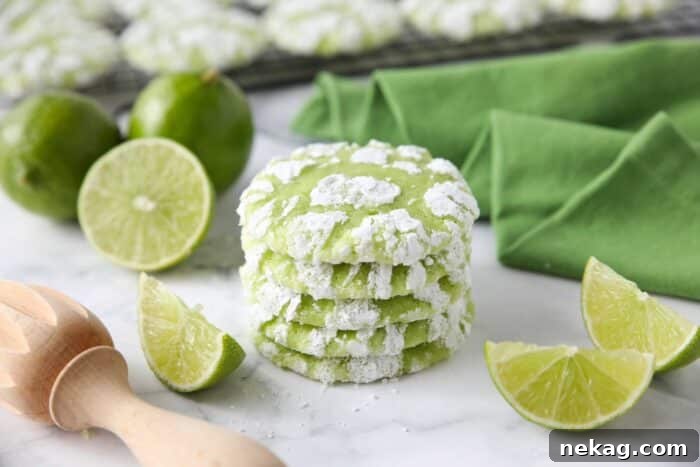 Stack of lime crinkle cookies with powdered sugar.