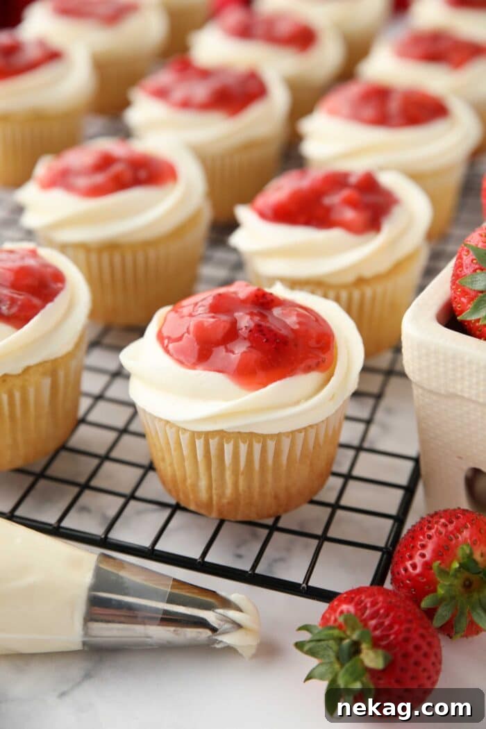 Strawberry Shortcake Cupcakes Recipe — Moist Strawberry Cupcakes 4 Strawberry Shortcake Cupcakes with strawberry sauce on top of whipped cream cheese frosting and a vanilla cupcake.