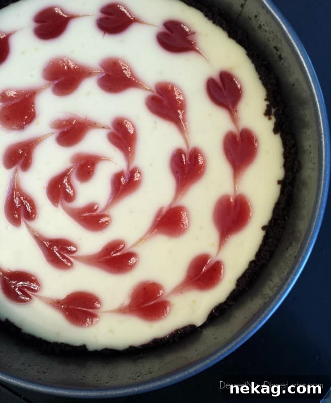Cheesecake in springform pan with strawberry hearts.