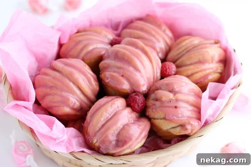 Layered raspberry butterflake rolls in a basket with raspberry glaze.