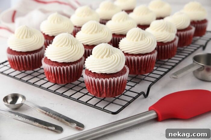Red Velvet Cupcakes with cream cheese frosting on a wire cooling rack.