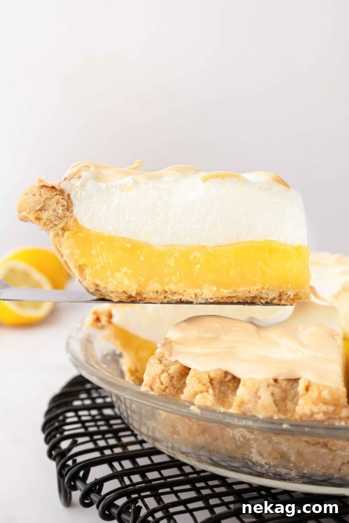 Classic Lemon Meringue Pie Recipe with Video Tutorial 5 Slice of lemon meringue pie being lifted out of the pan.