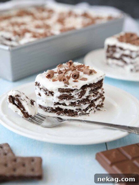 Icebox Cake with layers of chocolate graham crackers and whipped cream with chocolate curls on top.