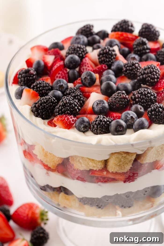 Red, White & Blue Berry Trifle Recipe with How-To Video 3 Close up of 4th of July trifle in a clear trifle bowl showing layers of pound cake, whipped cream cheese, and berries.