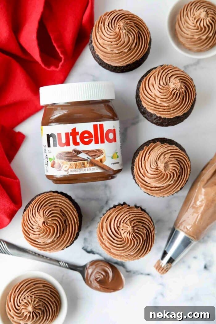 Jar of Nutella next to piped frosting on top cupcakes.
