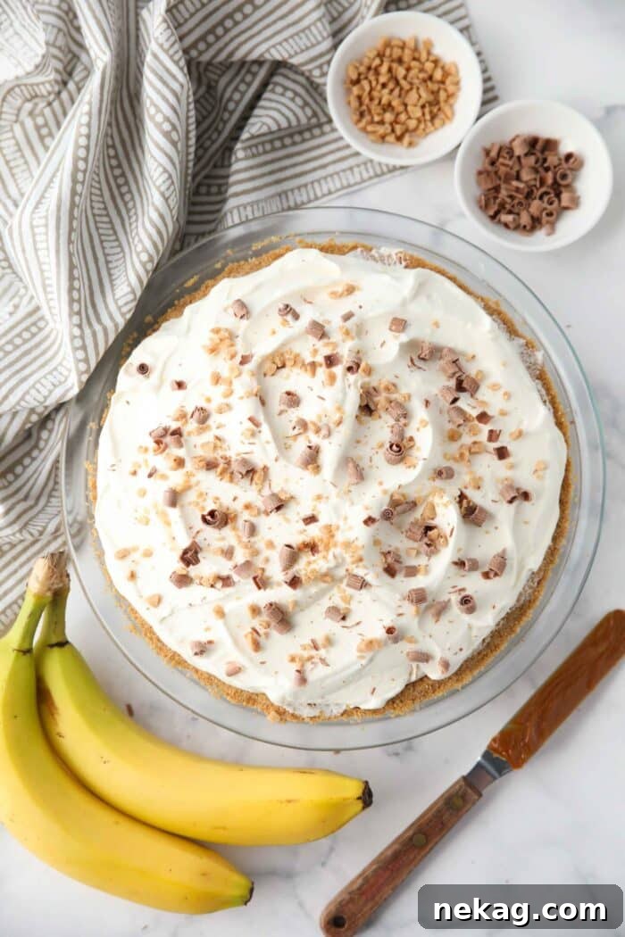 Top view of Banoffee Pie with whipped cream, toffee bits, and chocolate shavings.