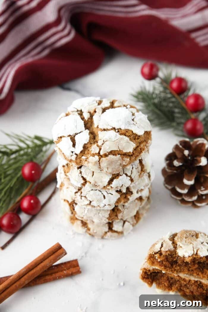 Stack of gingerbread Christmas crinkle cookies with powdered sugar cracks.