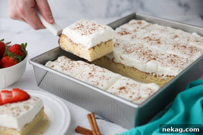Classic Tres Leches Cake Recipe: Moist Milk-Soaked Sponge 8 Scooping a piece of tres leches cake out of the pan.