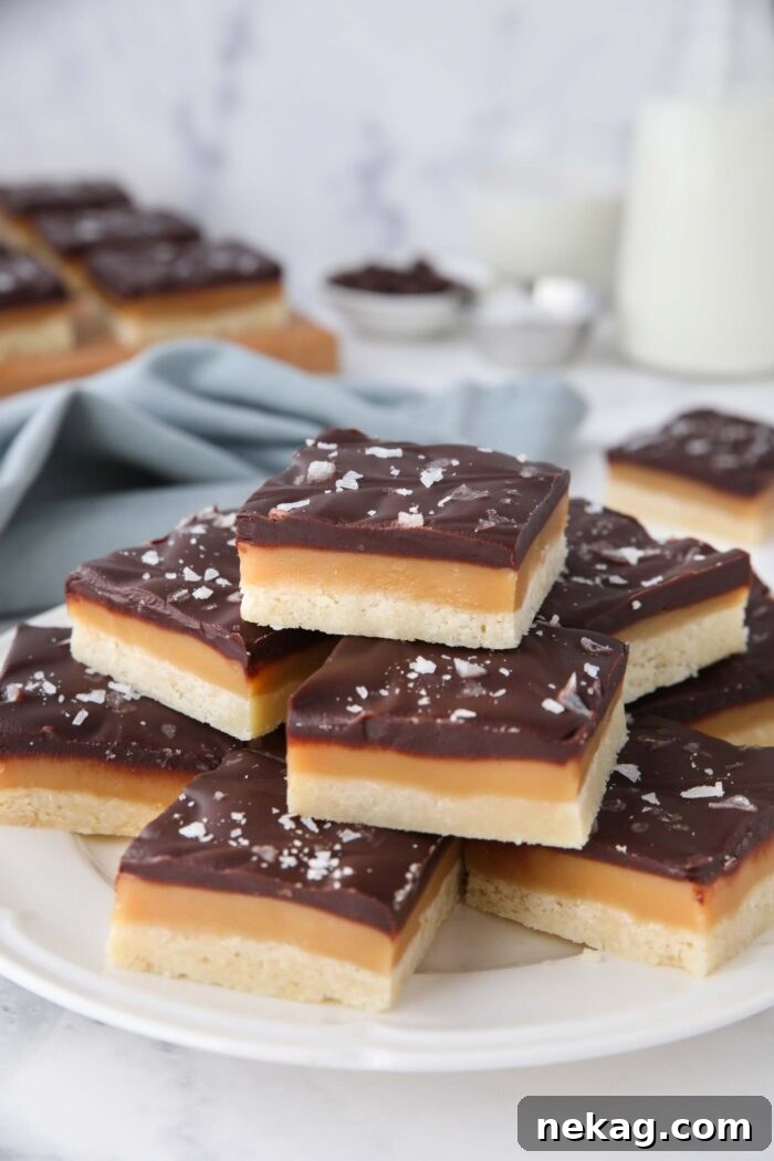 Plate full of caramel shortbread topped with chocolate and flaky salt.