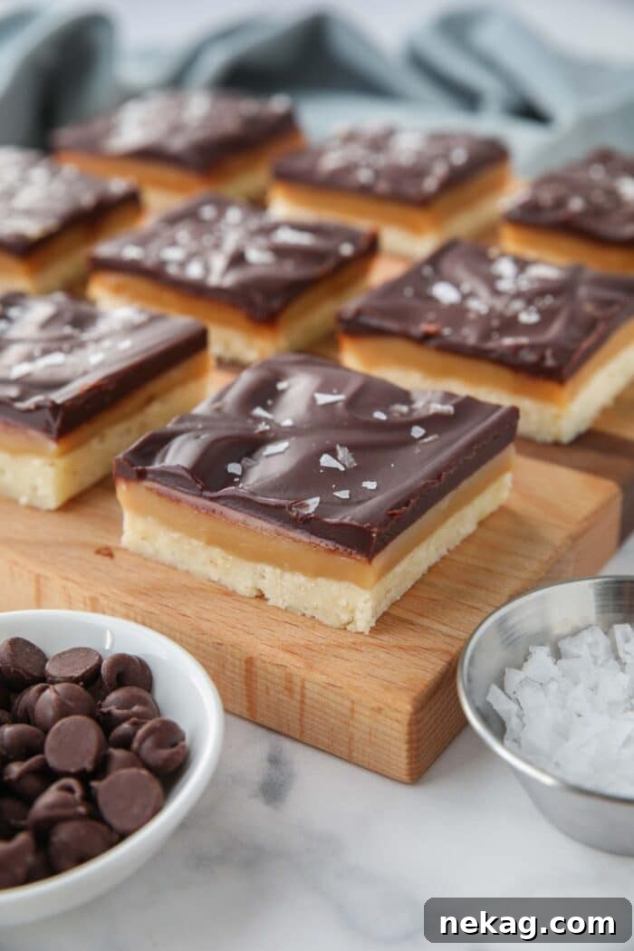 Squares of chocolate caramel slice on a cutting board.