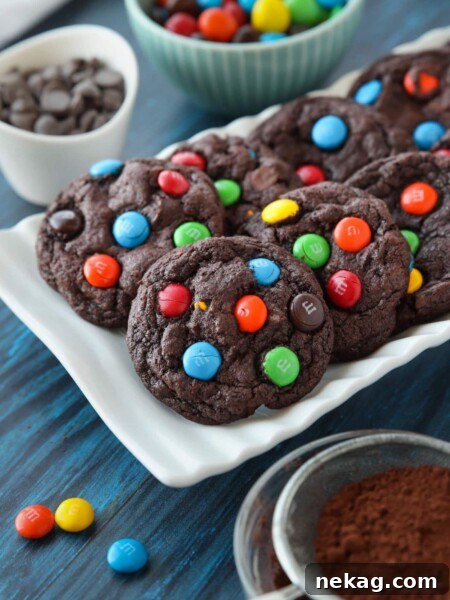 Chocolate cookies on a plate made with cocoa powder, chocolate chips and M&M's.