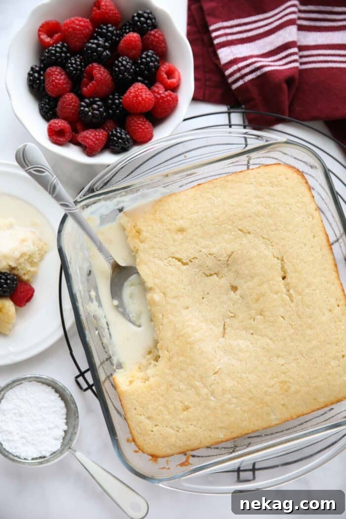 Top view of vanilla pudding cake in a baking pan with vanilla cake on top and vanilla pudding on bottom.