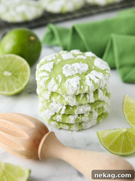 Stack of lime crinkle cookies with powdered sugar.