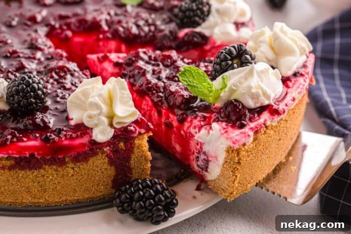 Lifting a slice of no bake summer berry cheesecake from the pan.
