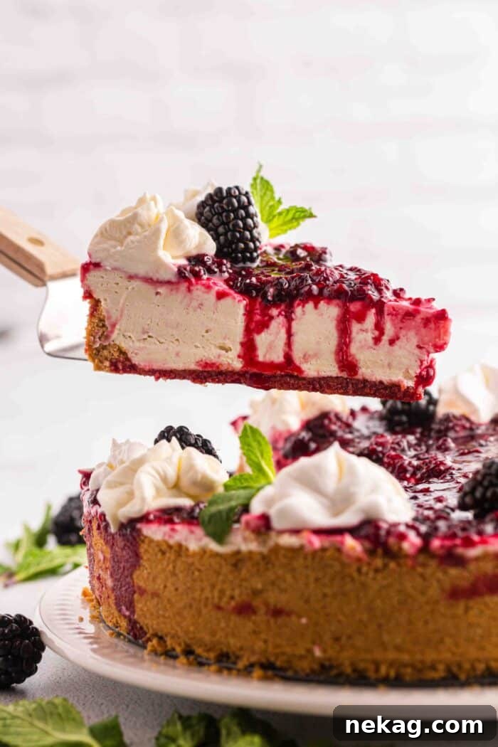Lifting a slice of no bake berry cheesecake from the pan.