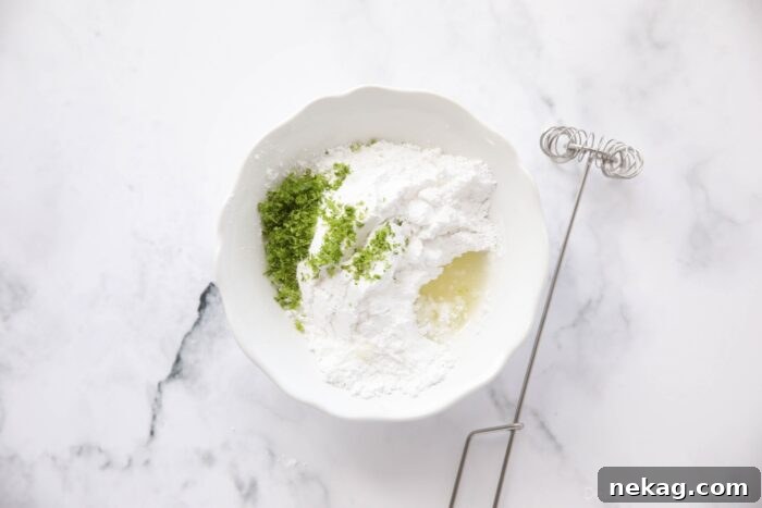 Lime glaze ingredients in a bowl with a whisk.