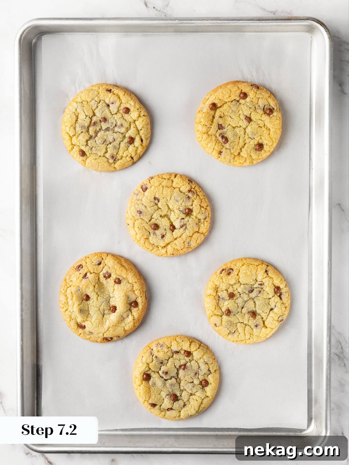 Freshly baked cookies on parchment-lined baking sheet with golden edges and soft centers.