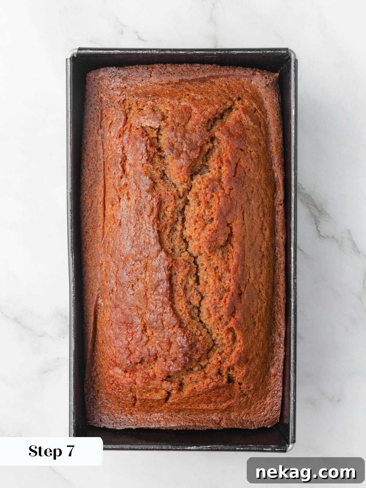 Moist Homemade Applesauce Bread Recipe 6 Deeply golden baked loaf with a cracked center crust still resting in its metal loaf pan.