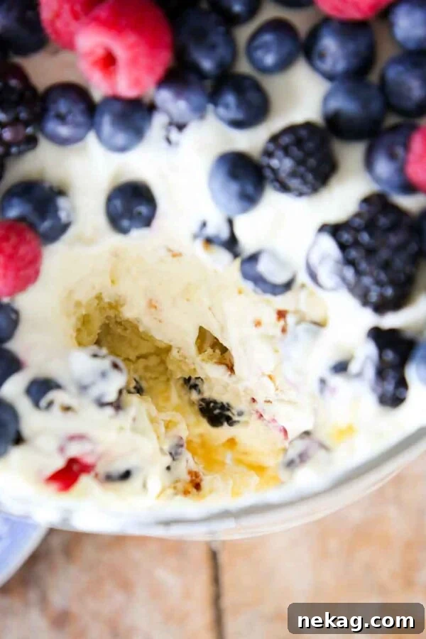 Top of trifle dish loaded with berries with serving missing.