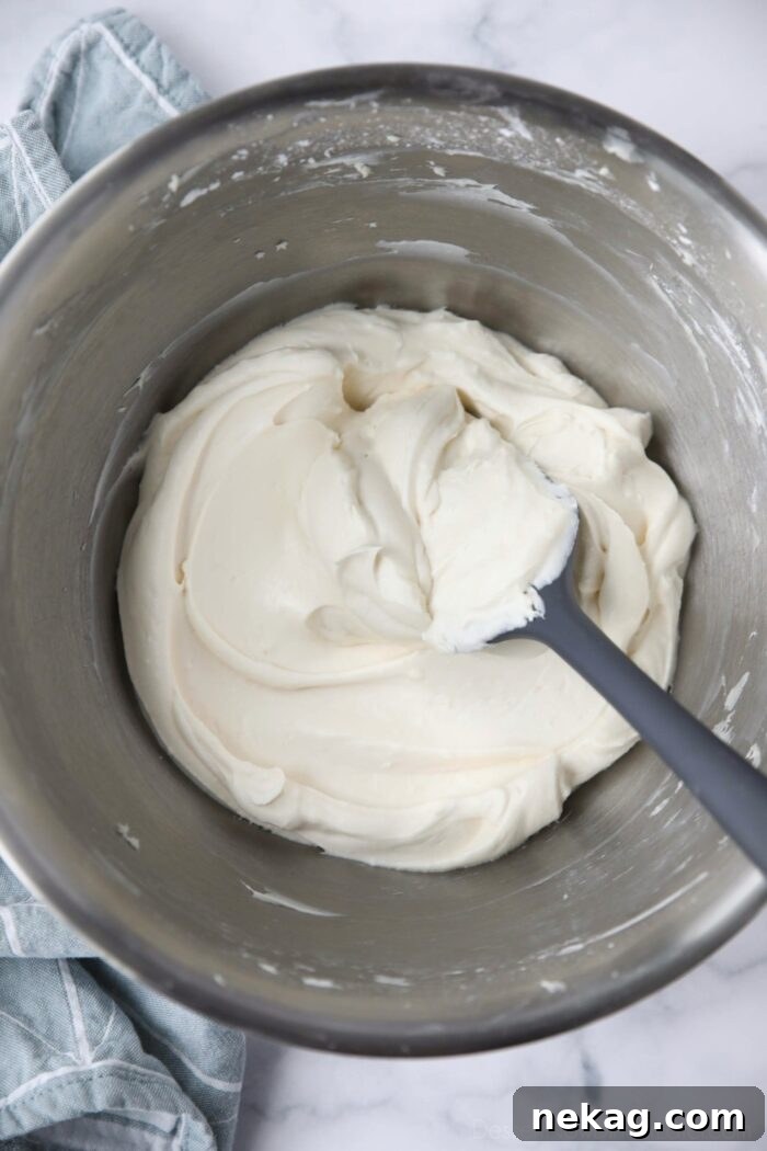 Cream Cheese Frosting Recipe with Video Tutorial 3 The best cream cheese frosting in a bowl with a spatula.