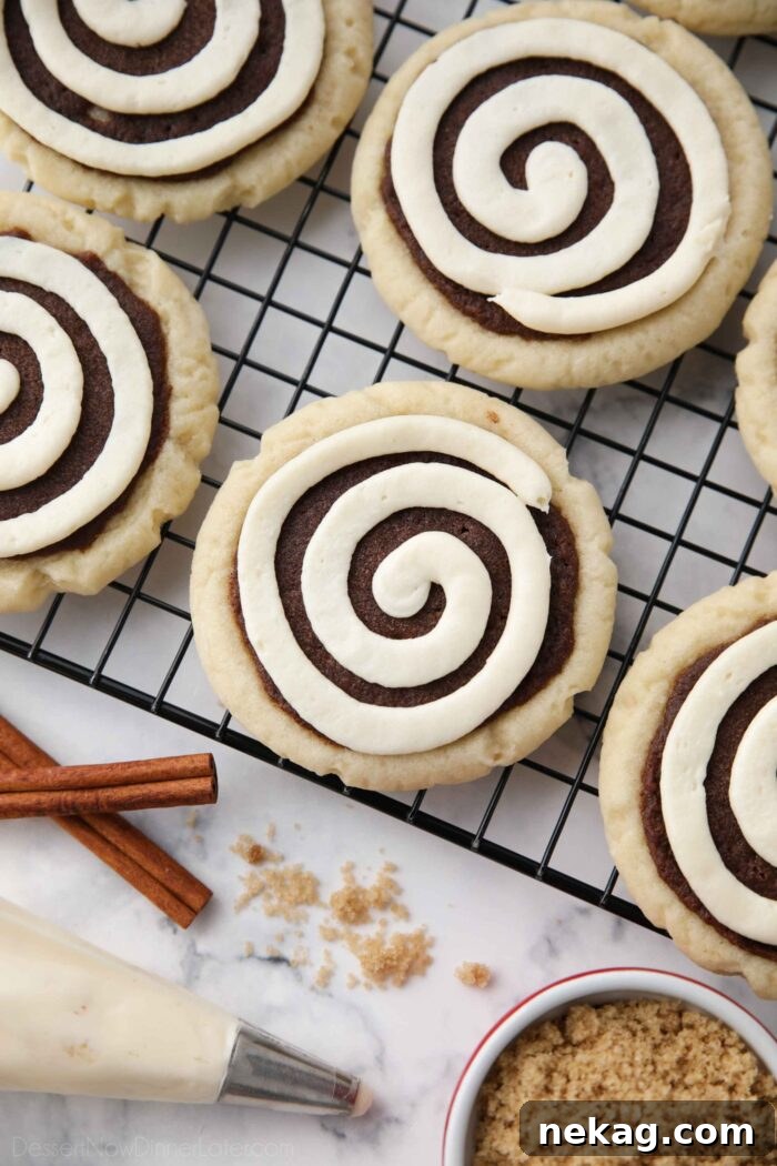 Top view of Cinnamon Roll Sugar Cookies with swirled frosting on a wire cooling rack.