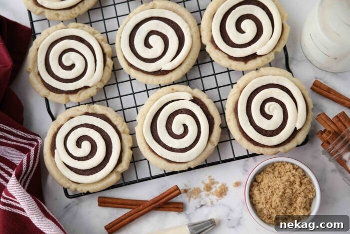 Top view of Cinnamon Roll Sugar Cookies with swirled frosting on a wire cooling rack.
