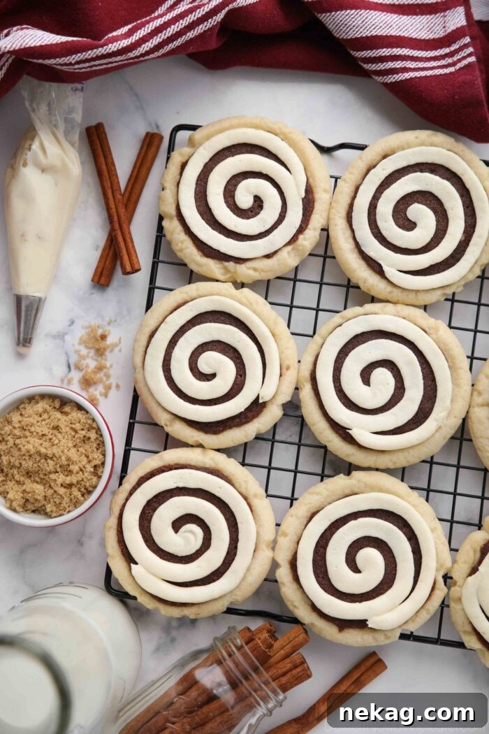 Top view of Cinnamon Roll Sugar Cookies with swirled frosting on a wire cooling rack.