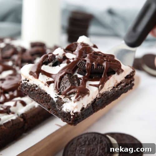 Cookies & Cream Brownies Recipe: Fudgy Oreo-Style Brownies 13 Scooping up a cookies and cream brownie with a spatula.