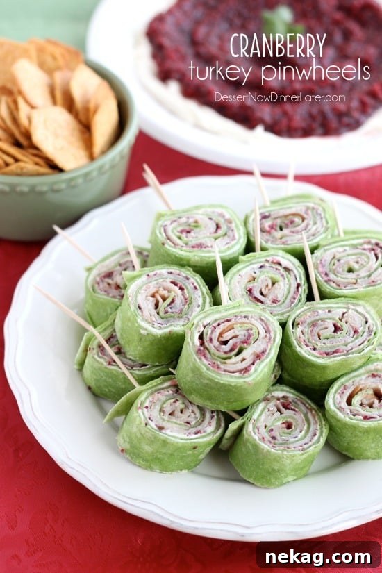 Cranberry Turkey Pinwheels have layers of cream cheese, spicy-sweet cranberry salsa, and thinly sliced turkey all rolled up in a spinach tortilla for a delicious party appetizer! From DessertNowDinnerLater.com