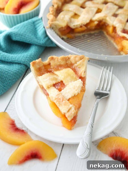 Slice of peach pie made with frozen peaches on a plate.