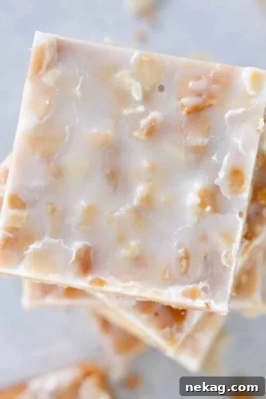 Square crispy almond cookies stacked on top of each other.