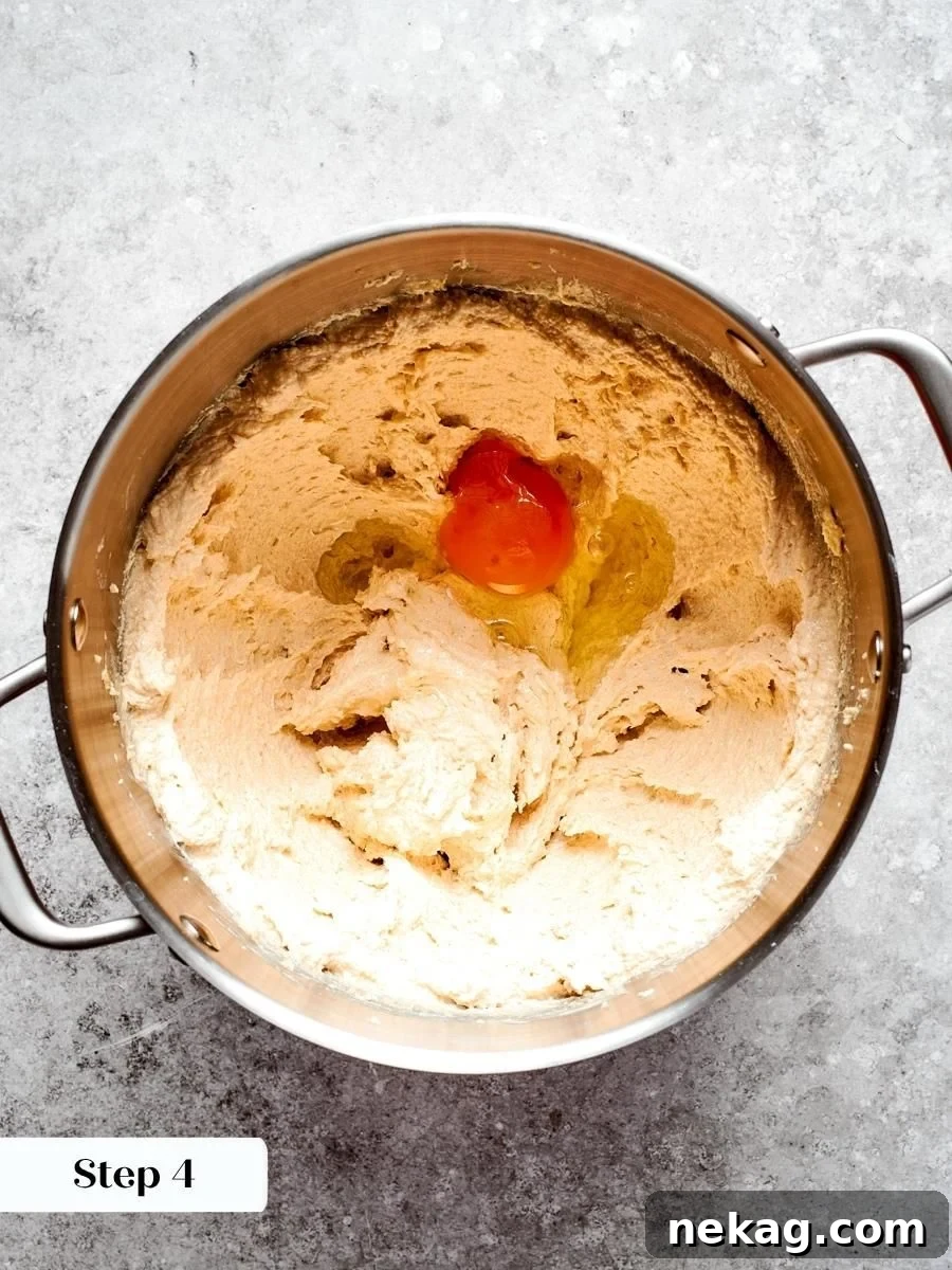 A room-temperature egg blends in smoothly, binding the oatmeal cream pie dough without breaking the emulsion.