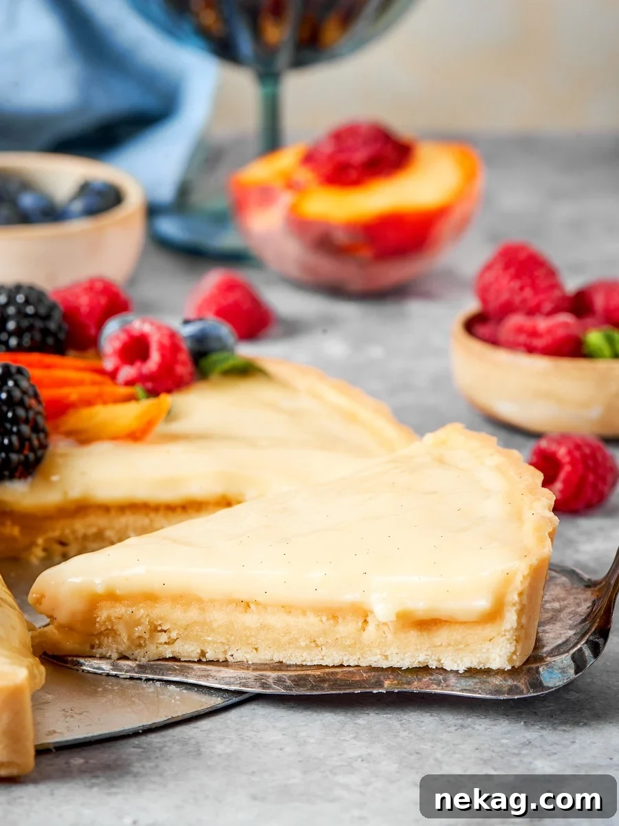 Classic Fresh Fruit Tart with Vanilla Pastry Cream 10 Serving from the side keeps the fruit tart layers legible rather than foreshortened.