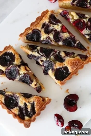 Classic Fresh Fruit Tart with Vanilla Pastry Cream 12 Cherry Almond Tart on marble board.