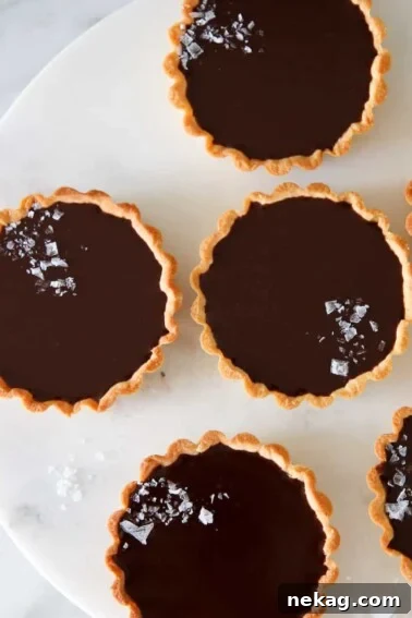 Classic Fresh Fruit Tart with Vanilla Pastry Cream 14 mini salted chocolate tarts on marble cake stand.