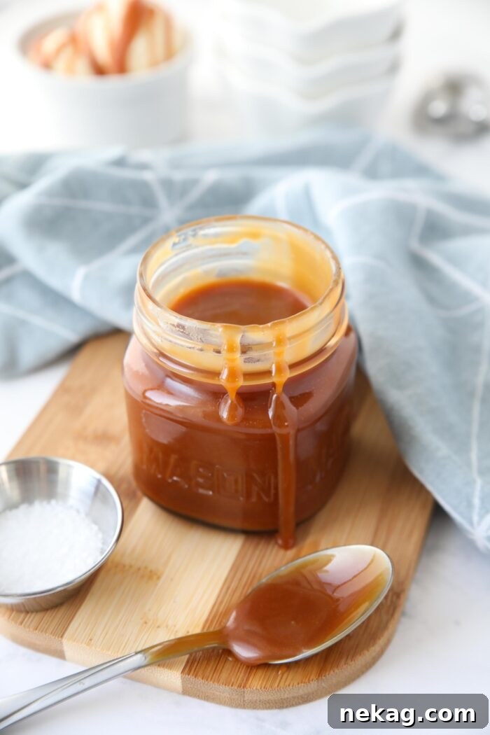 Homemade Salted Caramel Sauce Recipe 4 A jar of salted caramel sauce with drips down the side.