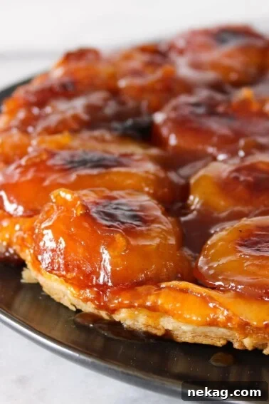 Apple Tarte Tatin on black plate.