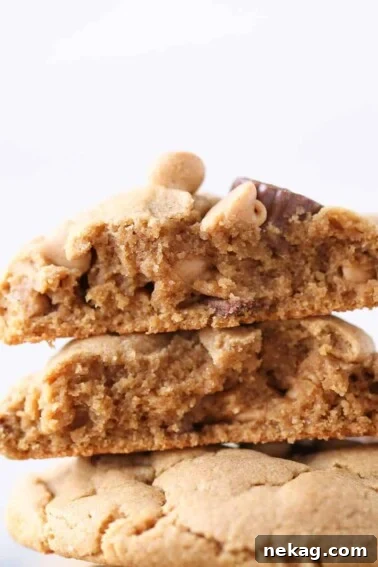 Loaded Reeses Peanut Butter Cookies stacked and sliced in half to see chewy texture.